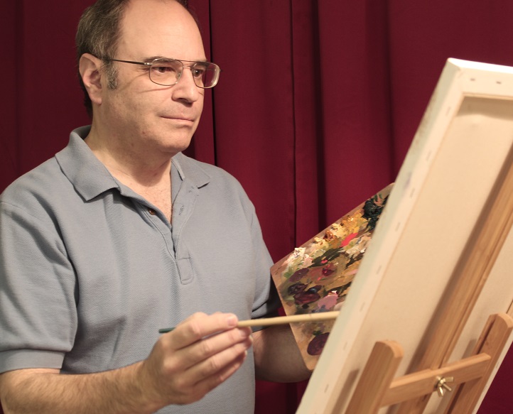 Artist standing at an easel with paintbrush in hand